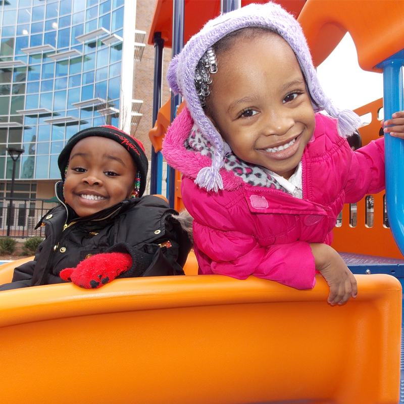 2 children playing at a park on TCC Norfolk Campus