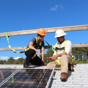 2 students learnign to install solar panels
